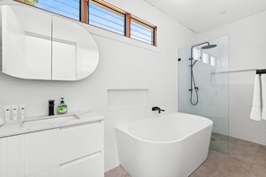 Appartement | Badkamer | Een bad, een haardroger, handdoeken, zeep