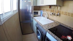 A compact kitchen with a stainless steel refrigerator, a microwave, a sink, and a washing machine. - Arco Nº 6 - nice studio in first line to the sea (Playa De Los Cristianos)