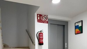 A staircase with a fire extinguisher and a door. - Don Diego - 2 bedroom in front of the beach (Playa De Los Cristianos)