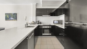 A modern kitchen with a large island, stainless steel appliances, and a microwave. - Spacious 2-bed Apartment in Heart of Leura (Leura)