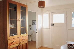 A room with a wooden cabinet, a white door, and a window.