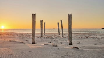 A beach with wooden posts and a sunset.