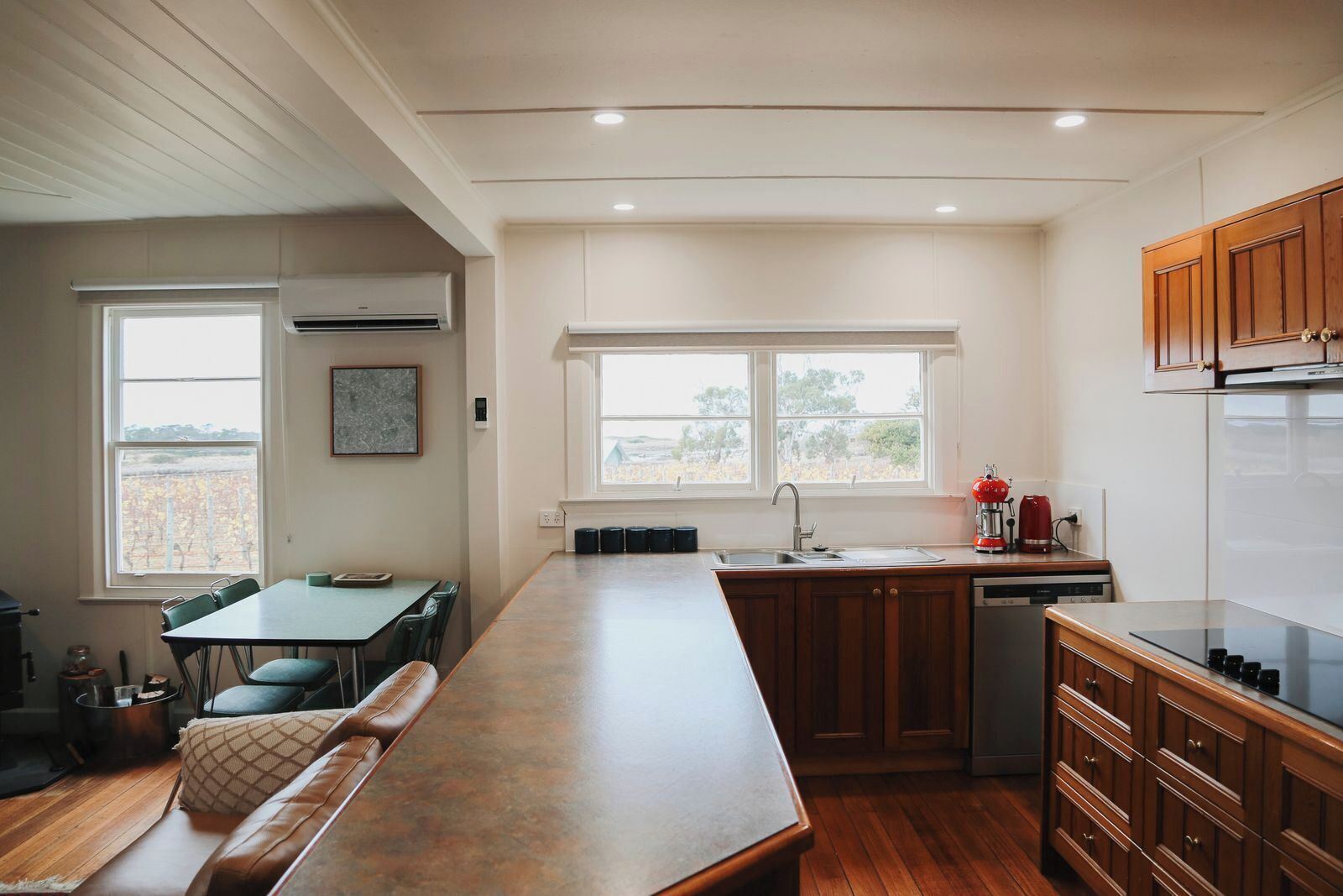 A modern kitchen with a central island, built-in cabinets, and a window providing natural light.
