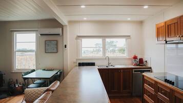 A modern kitchen with a central island, built-in cabinets, and a window providing natural light.
