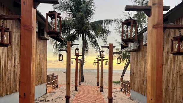 A wooden pathway leading to a beach with a view of the ocean.