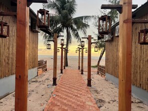 Un sentier en bois qui mène à une plage offrant une vue sur l’océan.