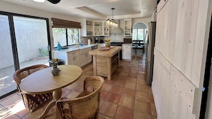 Una cocina moderna con comedor, ventanas amplias y un ventilador de techo.