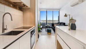 A modern kitchen with a built-in oven and a large window overlooking a cityscape. - Chic 1-bed With City Views, Parking, Gym & Pool (Melbourne)