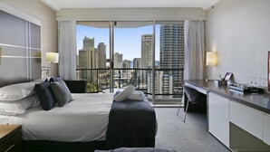 A hotel room with a large bed, a desk, and a balcony with a city view. - Ocean View 2-bed Studio In the Heart of Surfers (Gold Coast)