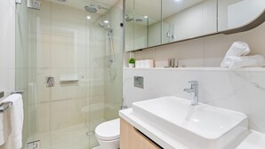 A modern bathroom with a glass-enclosed shower, a white sink, and a toilet. - City Views & Inner-north Cool at Your Door (Melbourne)
