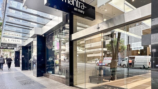 A modern building with a glass facade and a sign reading "mantra on monday."