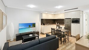 A modern apartment with a living room, dining area, and kitchen.