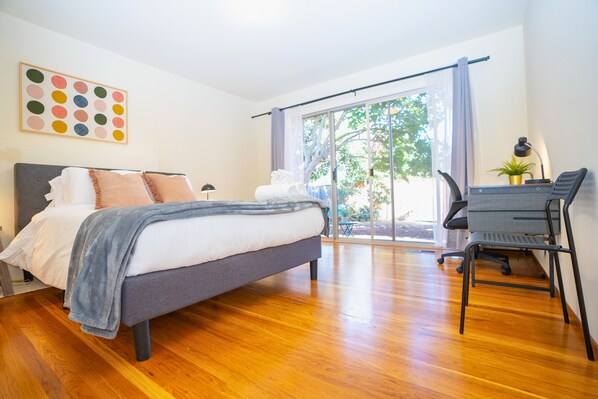 Une chambre moderne avec un lit, un bureau et une vue sur l’extérieur.