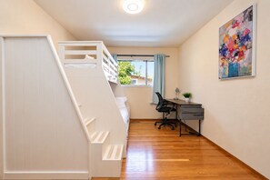 A bedroom with a bunk bed, a desk with a chair, a window with curtains, and a painting on the wall. - Central 3BR Home - Steps from Mountain View DT, Castro St (Mountain View)