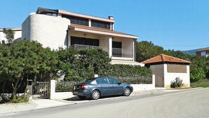 A modern two-story house with a car parked in front. - Apartment in Jadranovo With Parking Space (Crikvenica)