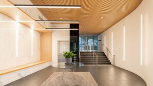 A modern interior with a curved staircase, a potted plant, and a glass table.