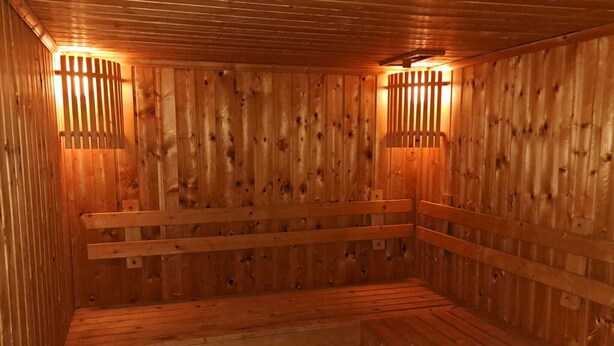 A wooden sauna with benches and slatted walls. - Harmony Living Condominium (Bangkok)