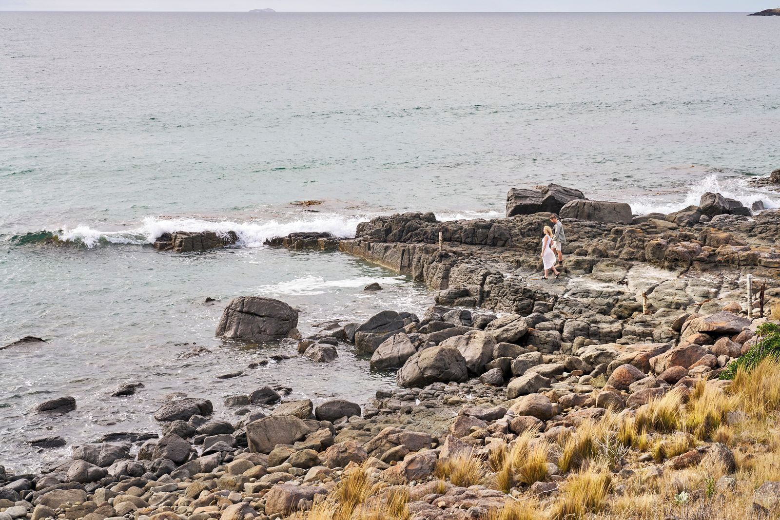 A rocky shoreline with waves crashing against the rocks.