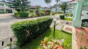 A well-maintained garden with a variety of plants and a paved walkway.