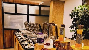 A buffet setup with various food items and beverages, including nuts and a bowl of what appears to be a fruit salad. - Hotel Abhinandan (Bhopal)