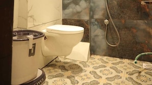 Ein Badezimmer mit Toilette, Dusche und Toilettenpapierhalter.