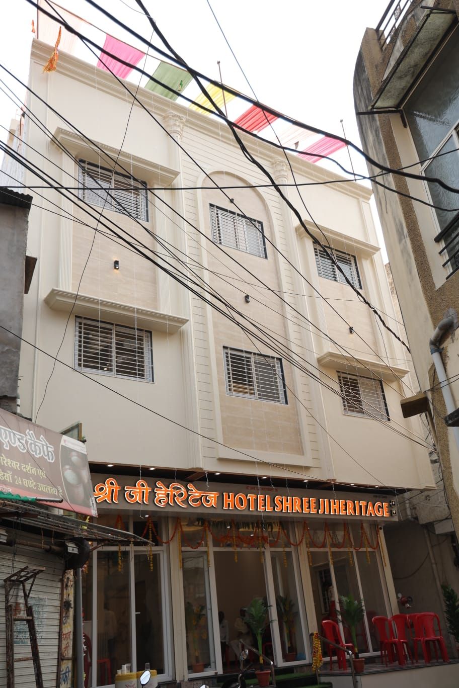 Un hôtel appelé « Shree Ji Heritage Hotel », doté d’une entrée bien visible et d’un espace extérieur aménagé pour s’asseoir.