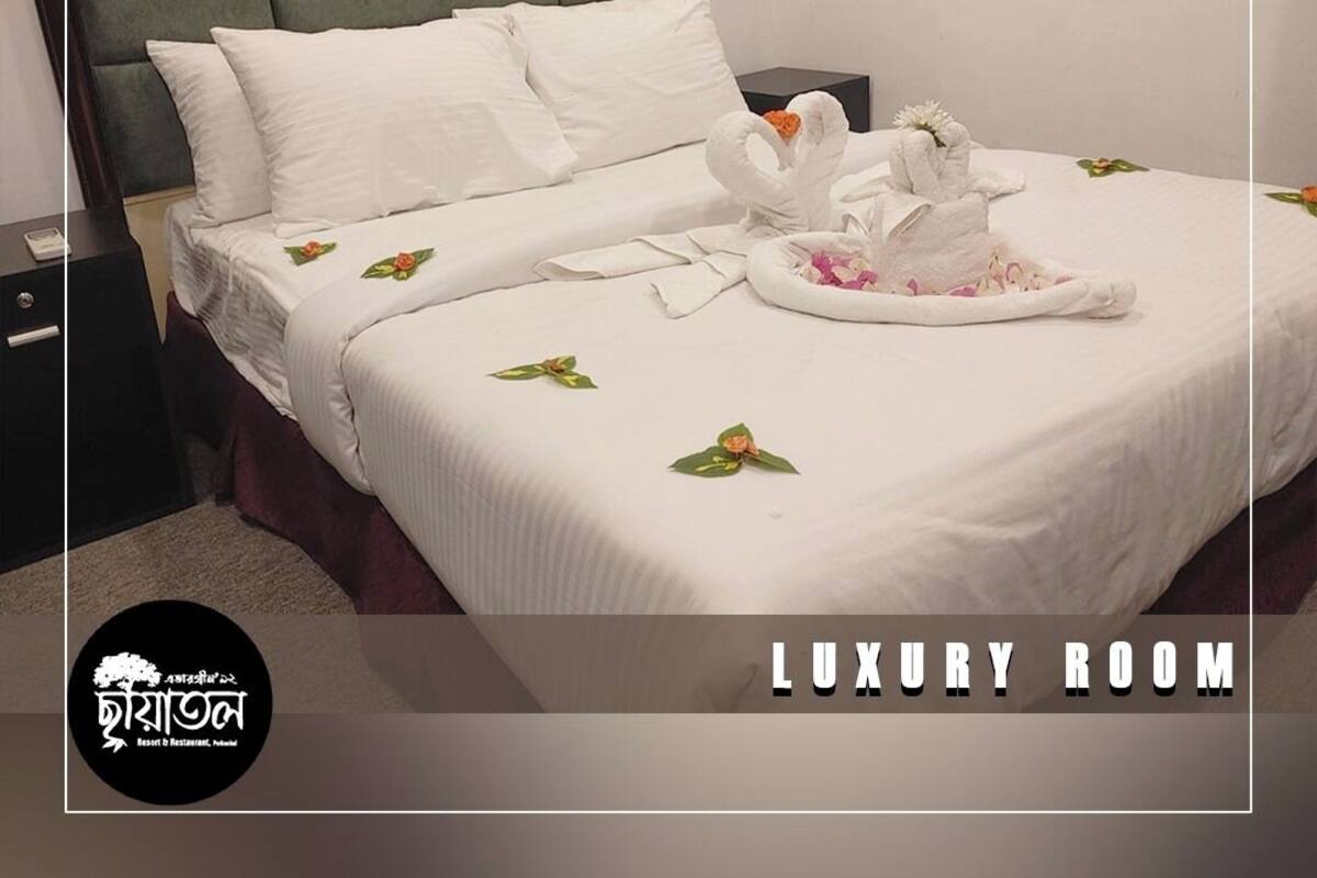 Ein luxuriöses Zimmer mit einem ordentlich bezogenen Bett, weißen Kissen und einem dekorativen Kopfteil.
