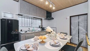 Et moderne køkken med spiseplads, udstyret med køleskab, mikrobølgeovn og komfur.