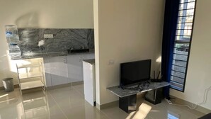 Uma cozinha moderna com painel de parede de mármore, fogão embutido e janela com persianas.