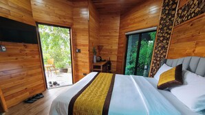 Ein Schlafzimmer einer Holzhütte mit einem Bett, einem kleinen Tisch und einem Stuhl.