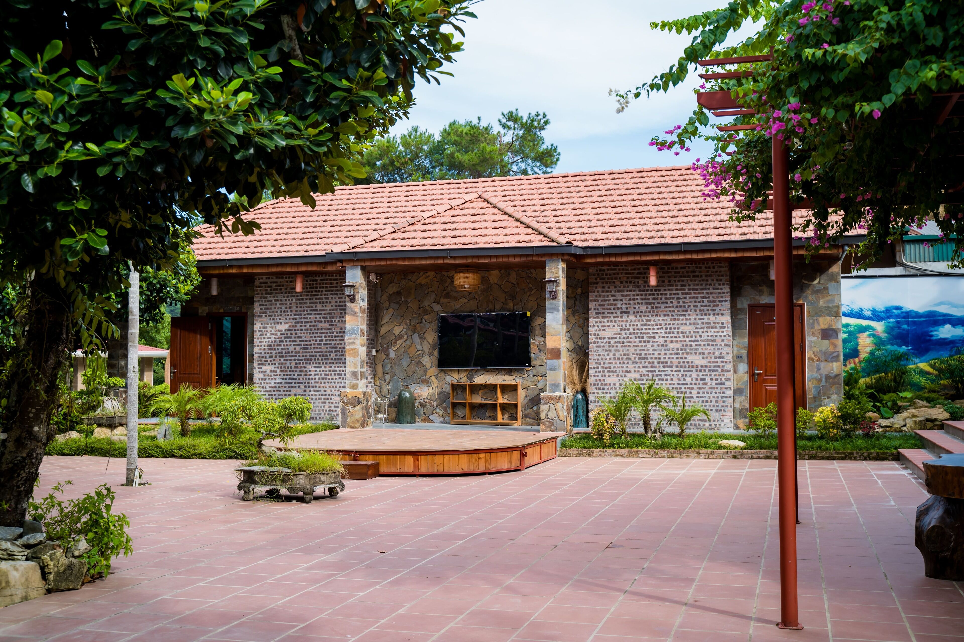 A building with a tiled roof, stone walls, and a stage area.