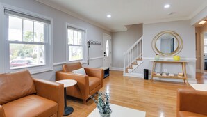 A spacious living room with leather sofas, a coffee table, and a staircase leading to another level.