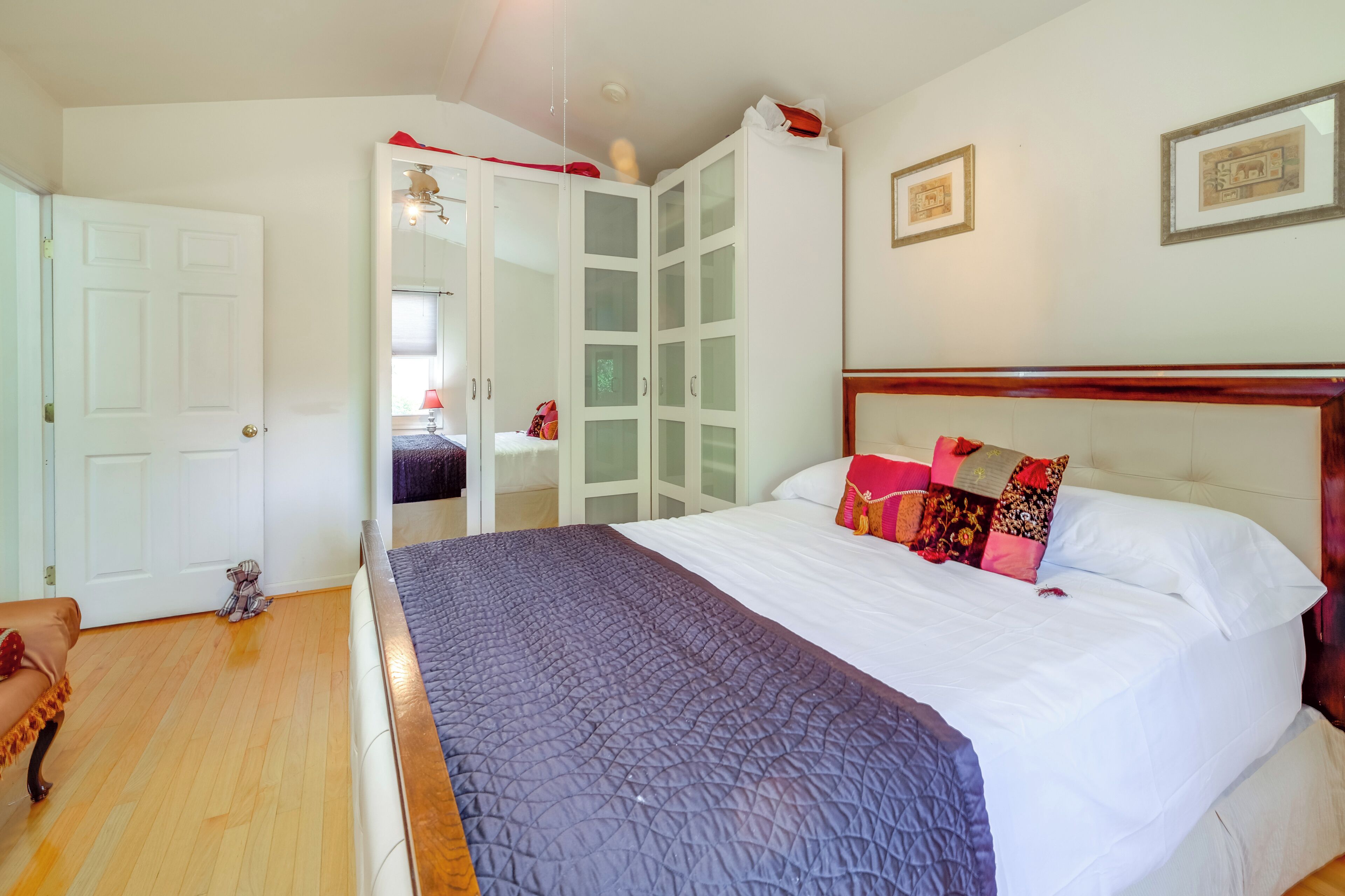 A bedroom with a bed, a wardrobe, and a door.