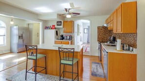Ett modernt kök med träskåp, en köksö och två barstolar.