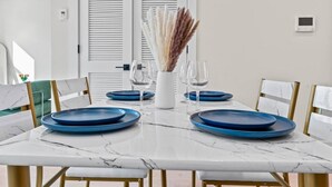 A dining table set with blue plates, wine glasses, and a vase with dried pampas grass. - Gallery Flat by Dupont Circle Large patio & Grill (Washington)