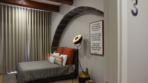 Ein modernes Schlafzimmer mit einem Bett, einer Wandlampe und einem dekorativen Wandbild.