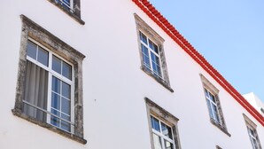 A building with multiple windows and a red roof. - GuestReady - Casa das Arcadas - Room 1 (Ponta Delgada)