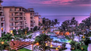 A resort with multiple-story buildings, a swimming pool, and palm trees. - Ocean front with new,updated interior.  Oversized balcony with BBQ. Perfect!! (Cabo San Lucas)