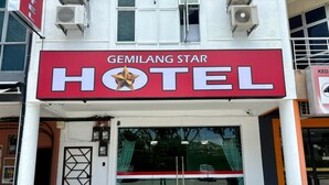 The exterior of Gemilang Star Hotel with a prominent red and white sign, large glass entrance, and air conditioning units on the facade. - Gemilang Star Hotel (Port Dickson)
