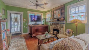 Uma sala de estar acolhedora com lareira, televisão e estante de livros.