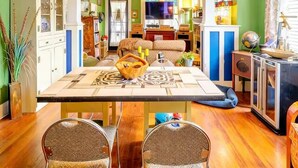 Uma área de refeições com uma mesa central, cadeiras e luminárias pendentes azuis.