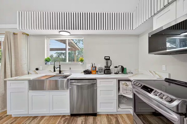 A modern kitchen with a built-in dishwasher, a stove, and a coffee maker.