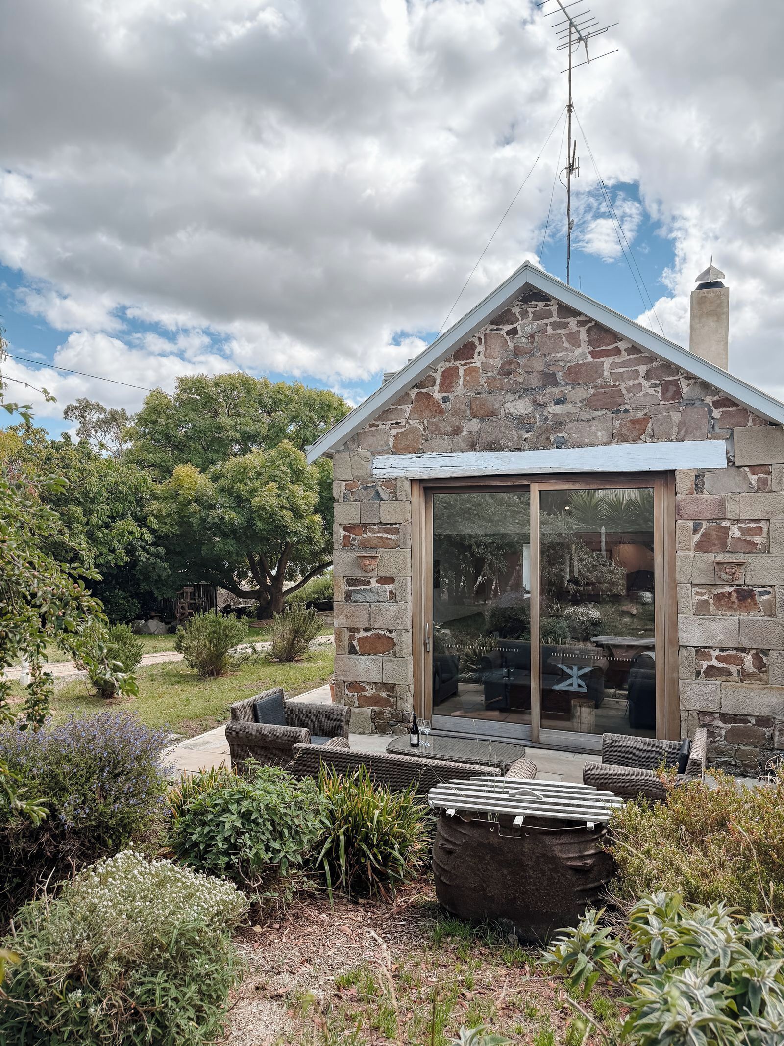 Una casa in pietra con una porta vetrata e un piccolo portico.