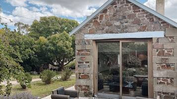 Una casa in pietra con una porta vetrata e un piccolo portico.