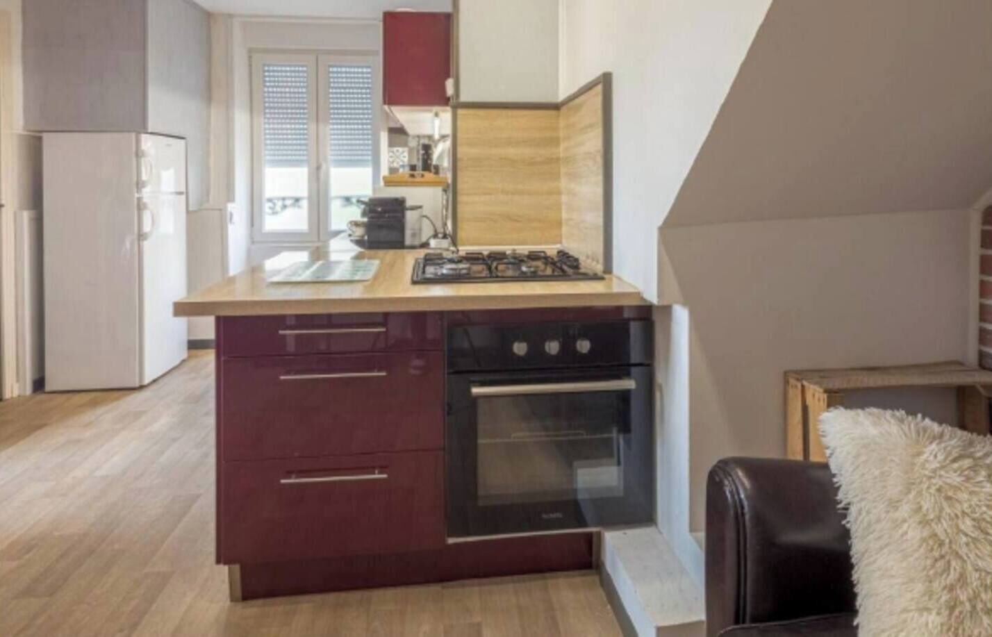 A compact kitchen with a built-in oven and a gas stove.
