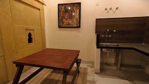 A small, compact kitchen with a wooden table and a sink. - Svarn By Experience Jaisalmer (Jaisalmer)