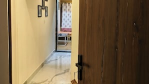 A hallway with a wooden door labeled "Kiran Apartment HK6". - Svarn By Experience Jaisalmer (Jaisalmer)