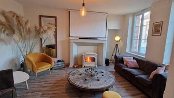 Télévision, cheminée, table de tennis de table, livres