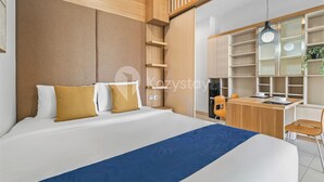 Une chambre d’hôtel moderne, dotée d’un grand lit, d’un bureau et d’une étagère.
