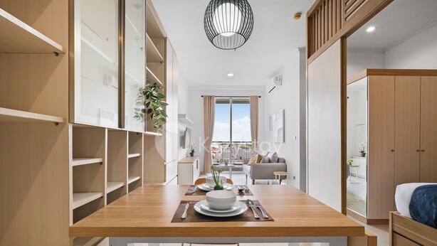 Une pièce moderne et bien éclairée, avec une table à manger en bois dressée pour deux personnes, un canapé et un lit.